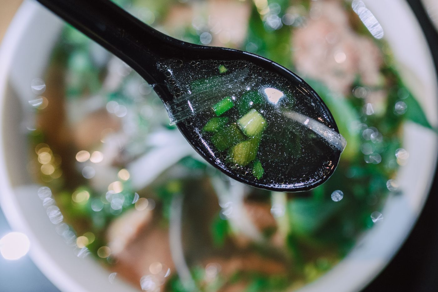 Klar bouillon med en ske over skålen